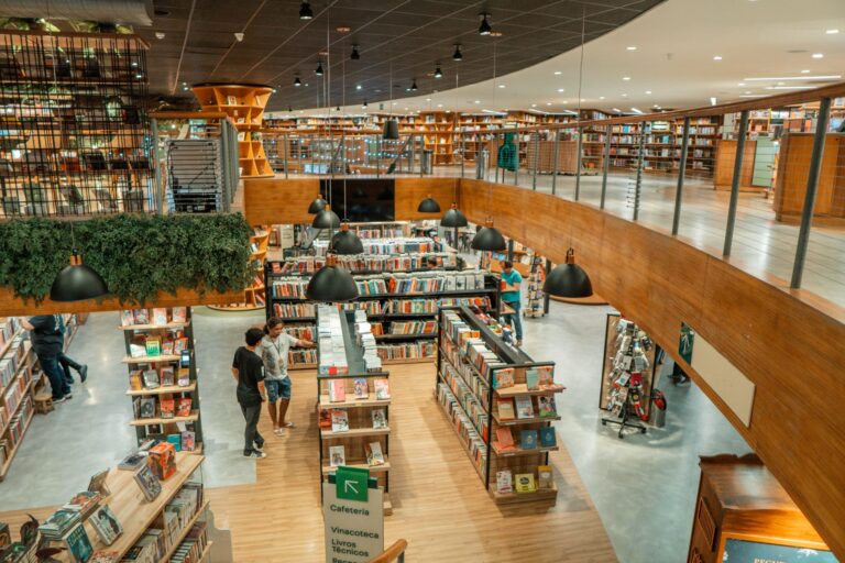 A modern bookstore filled with shelves of books and people browsing in a wooden interior.