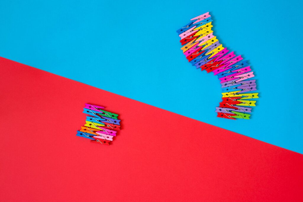 A creative arrangement of colorful clothespins on bright red and blue backgrounds.