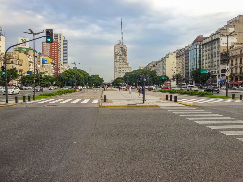 View of Avenida 9 de Julio with iconic buildings and traffic in Buenos Aires, Argentina.