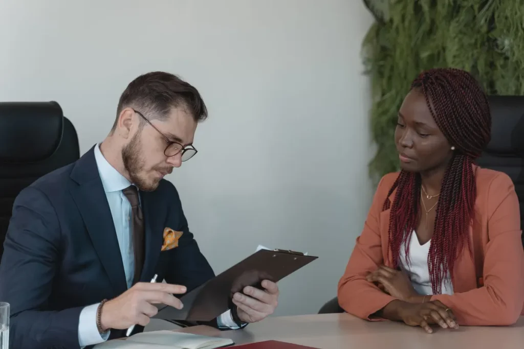 A man and woman engaging in a job interview in a modern office setting.